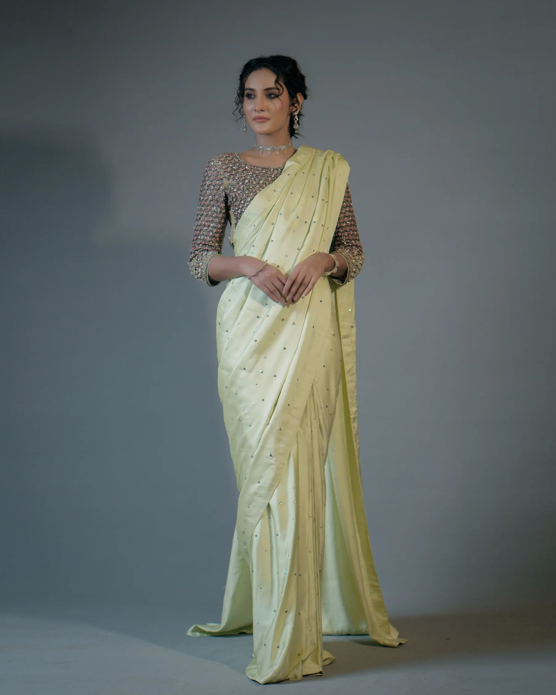 Woman modelling an elegant ivory saree with detailed blouse